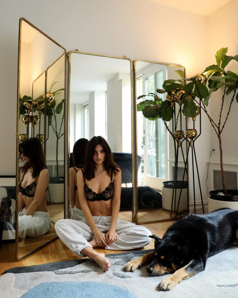 EmRata on the floor of her apartment with her dog Colombo, wearning black bra