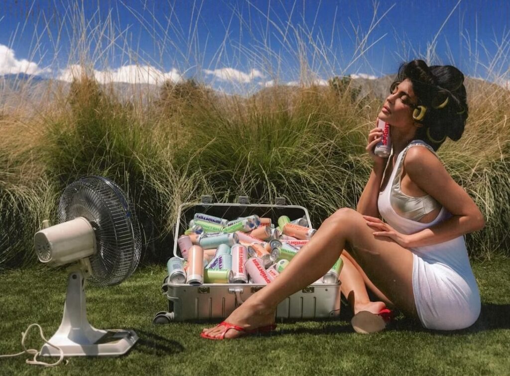 Kylie Jenner using a cold can of Sprinter to cool off