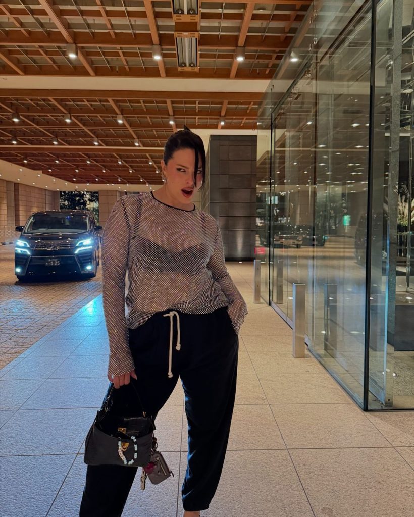 Ashley Graham layers a sparkling mesh top over a sleek black bralette